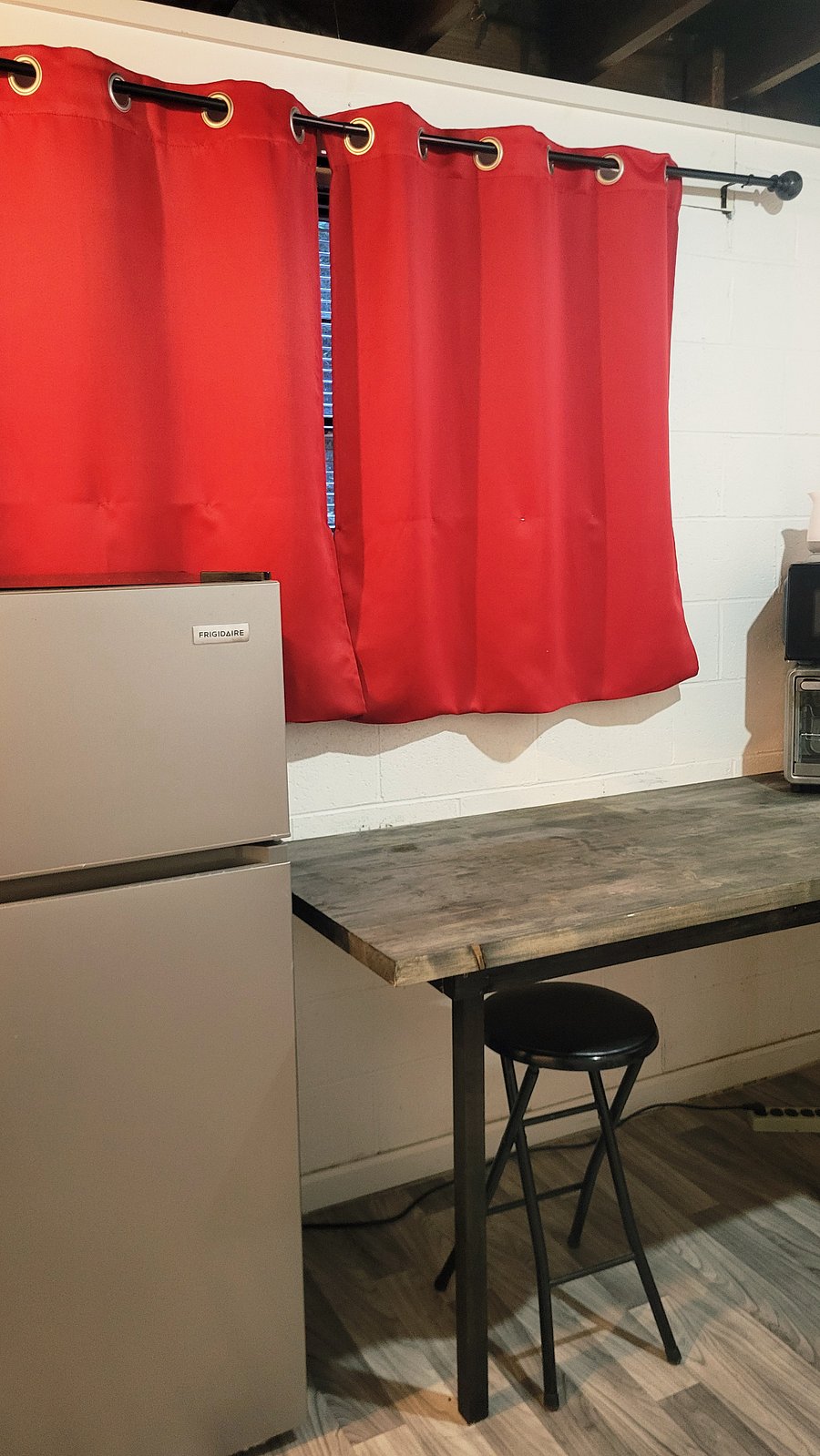 Kitchenette/Laundry Room with 7.5 cu ft. refrigerator and a separate area that includes a large utility sink, a wardrobe rack, & extra linens.