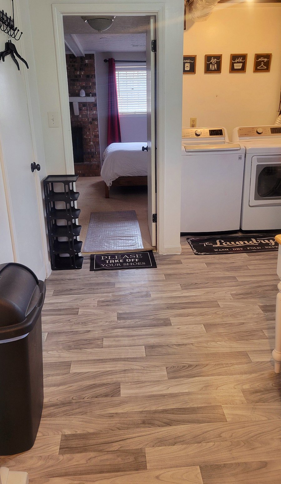 Kitchenette/Laundry Room with a separate area that includes a large utility sink, a wardrobe rack, & extra linens.