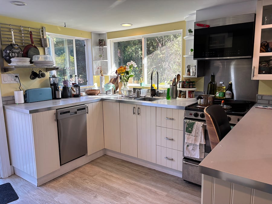 The kitchen has a small dishwasher, sink, and an electric range and microwave.