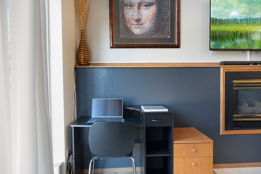 This workspace is centrally located in the living room, offering views of the front yard and easy access to both work and conversation.