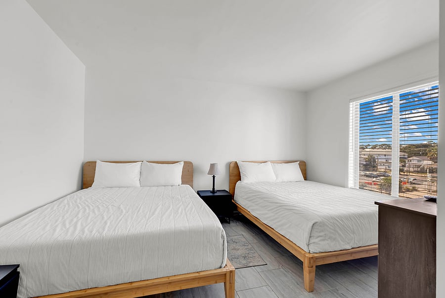 Guest bedroom with two queen beds and Smart TVperfect for comfort and flexibility.