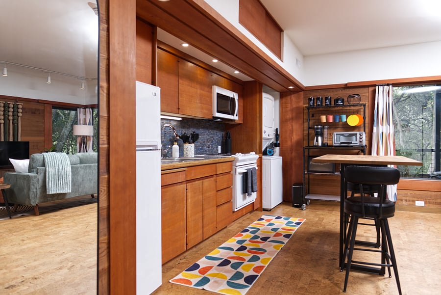 Stackable washer/dryer and bakers rack with new appliances - coffee maker, toaster oven, blender, and crock pot.
