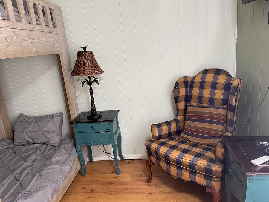 Bedroom 3 is located on the 2nd floor and consists of twin size bunk beds, side table with a lamp and an armchair. This bedroom has its own window a/c unit, a closet with hangers & tv.