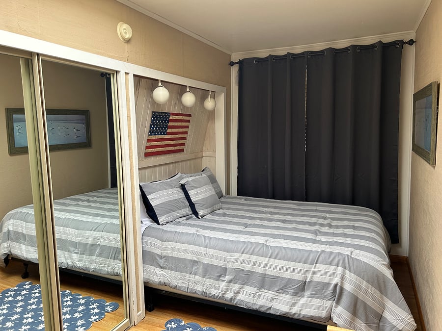 Main level bedroom with round window looking out through the solarium to an ocean view.