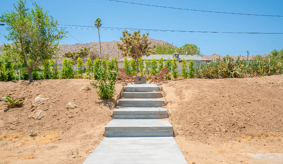 stargaze on the upper tier of the yard at the large circular patio. This yard is lined with ficus trees for privacy, and corrugated fencing adds even more security.