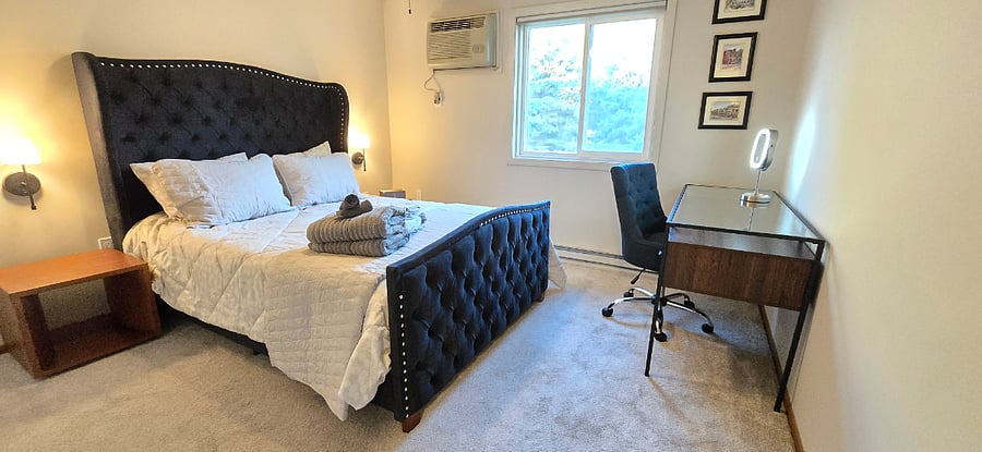 Master beddroom with queen bed with desk and makeup mirror