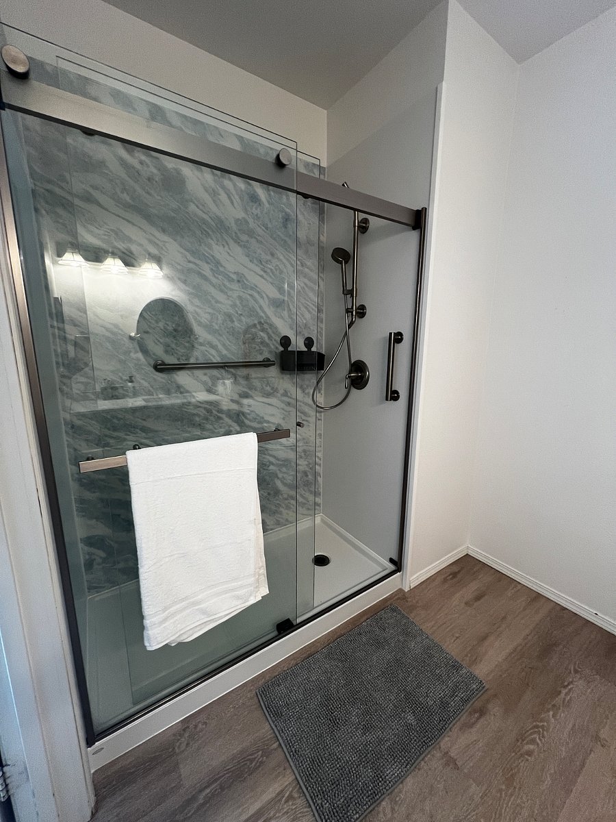 Main bathroom with walking shower and grab bars