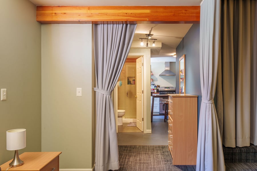 Looking from bed toward bathroom with kitchen in the background