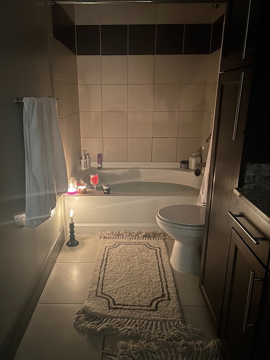 Full bathroom with large soaking tub, large mirror, and lots of storage