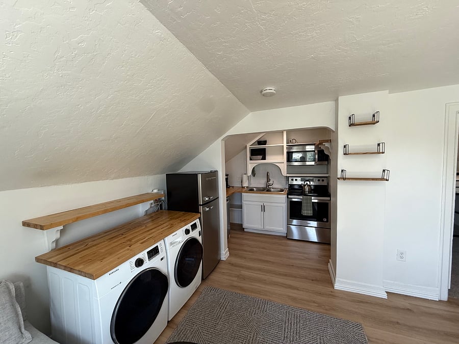 Compact but well-stocked kitchen with modern appliances, dishwasher, open shelving, and everything needed for a comfortable stay.