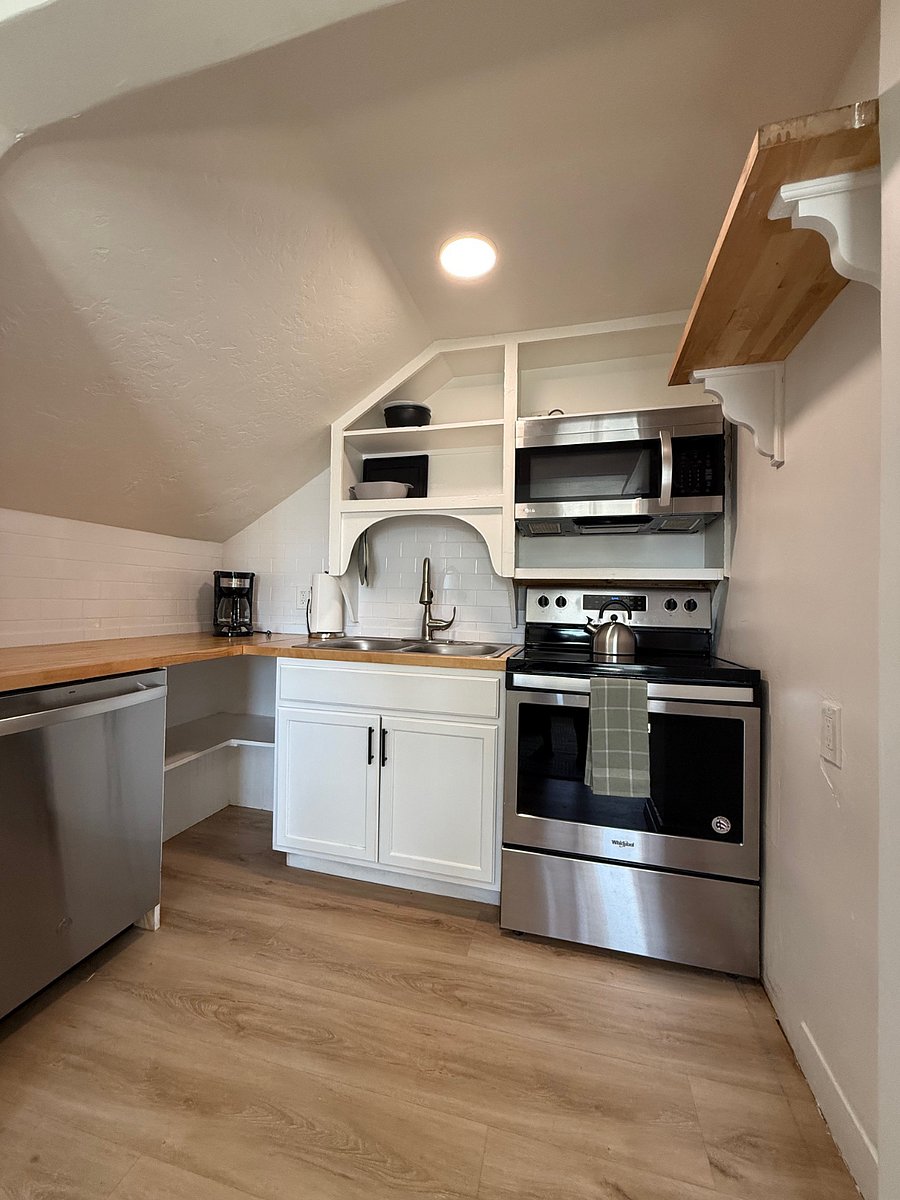 Compact but well-stocked kitchen with modern appliances, dishwasher, open shelving, and everything needed for a comfortable stay.
