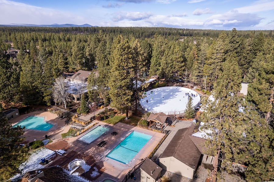Aerial view of 3 swimming pools, hot tubs, ice skating rink, locker rooms with sauna, and indoor gym. 