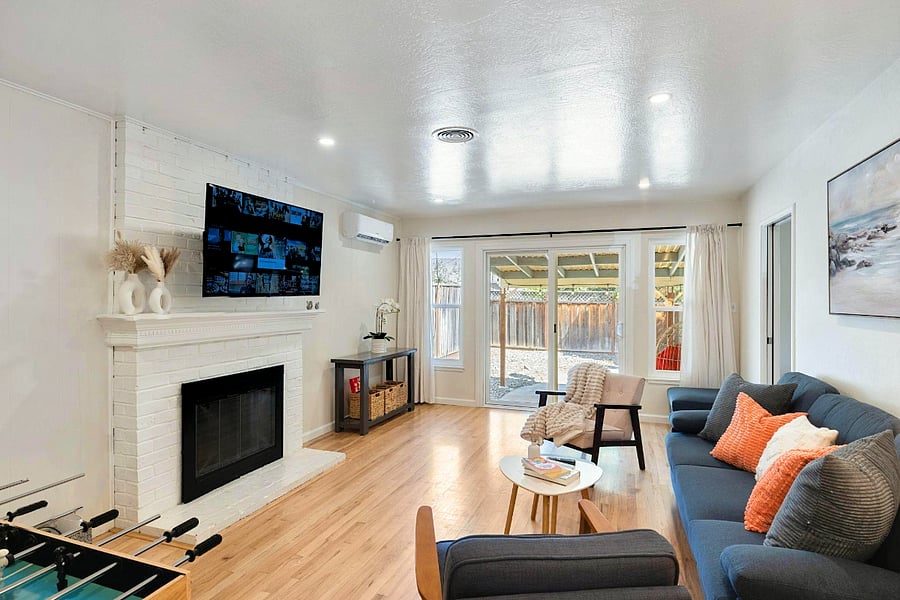 Cozy living room with a neutral palette, fireplace with built-in shelves, spacious gray sectional, large artwork, and wall-mounted TVperfect for relaxing and entertaining.