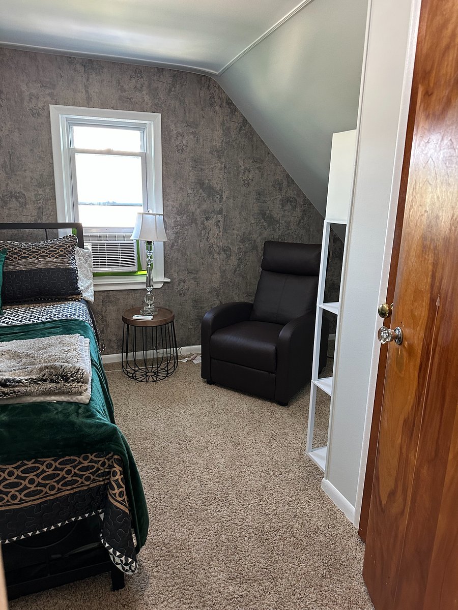 There is a private bedroom with full size bed, seating area with recliner, large walk-in closet, dresser, and smart tv. 