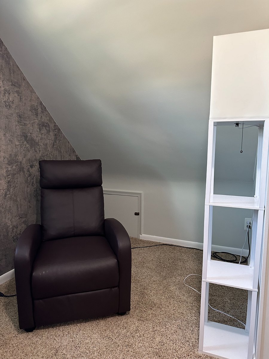 Bedroom offers a cozy seating area with comfortable recliner for relaxing or watching television.