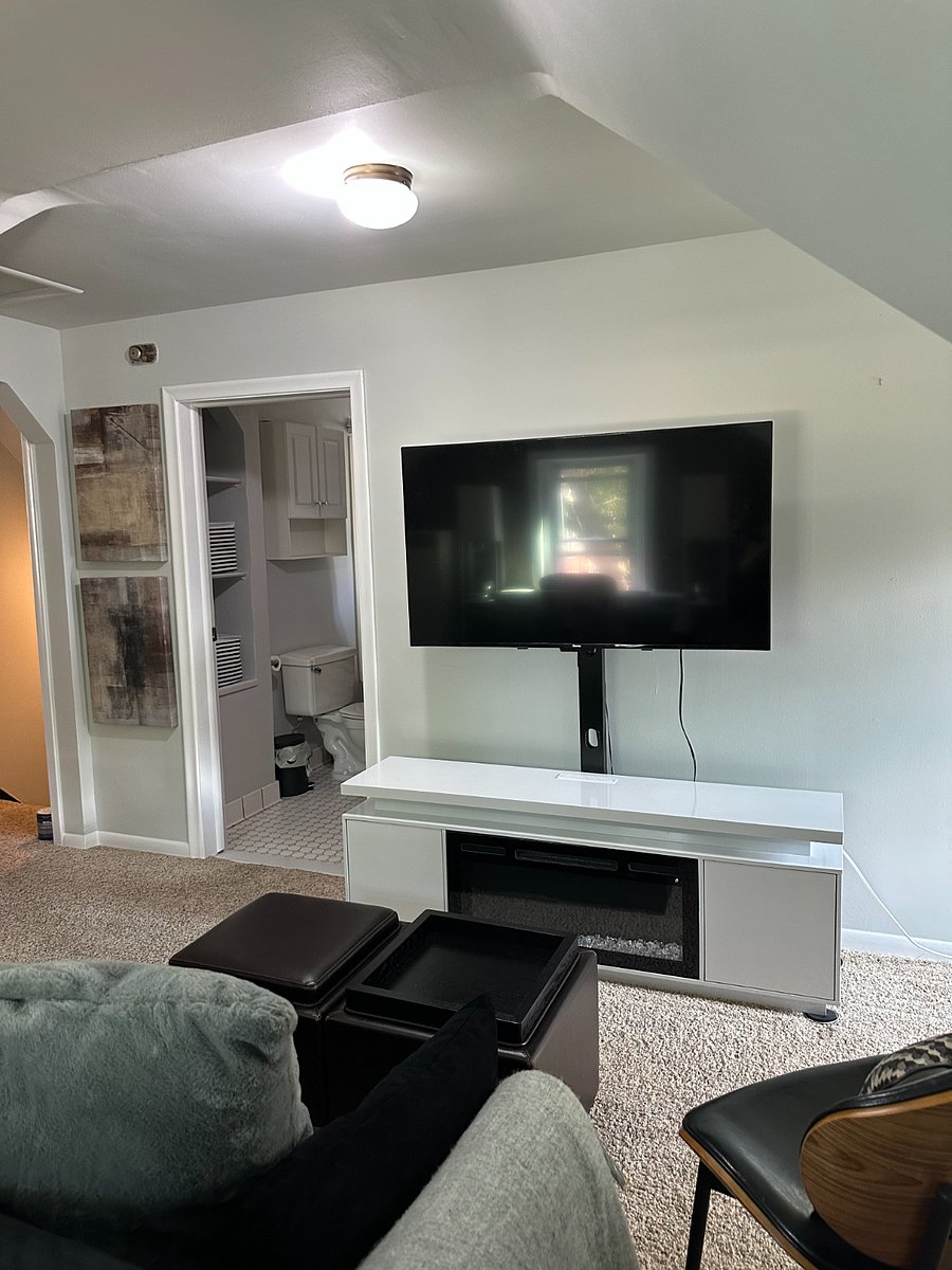 Additional view of the television, fireplace, and entrance to the renovated bathroom.