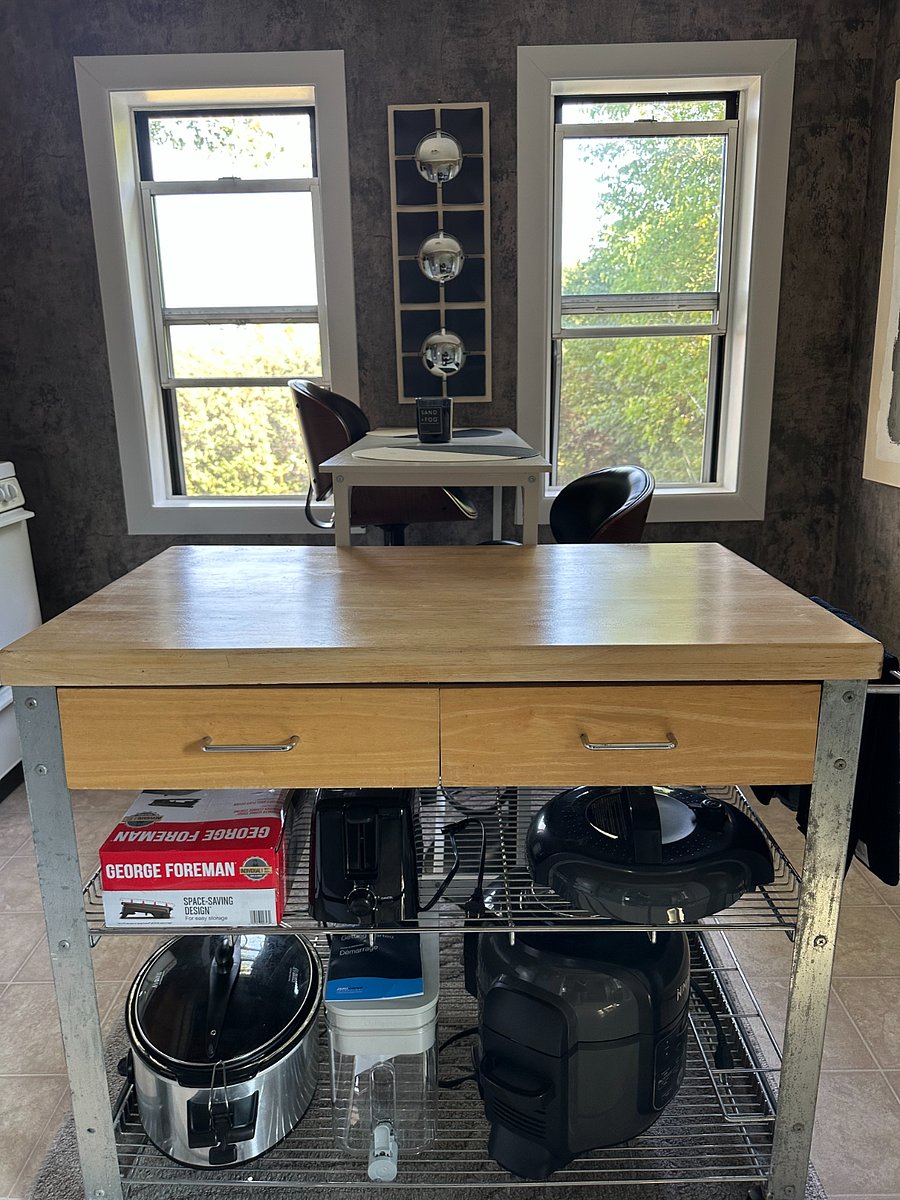 The kitchen offers an island and high-top dining table for two with lovely views of the private backyard.