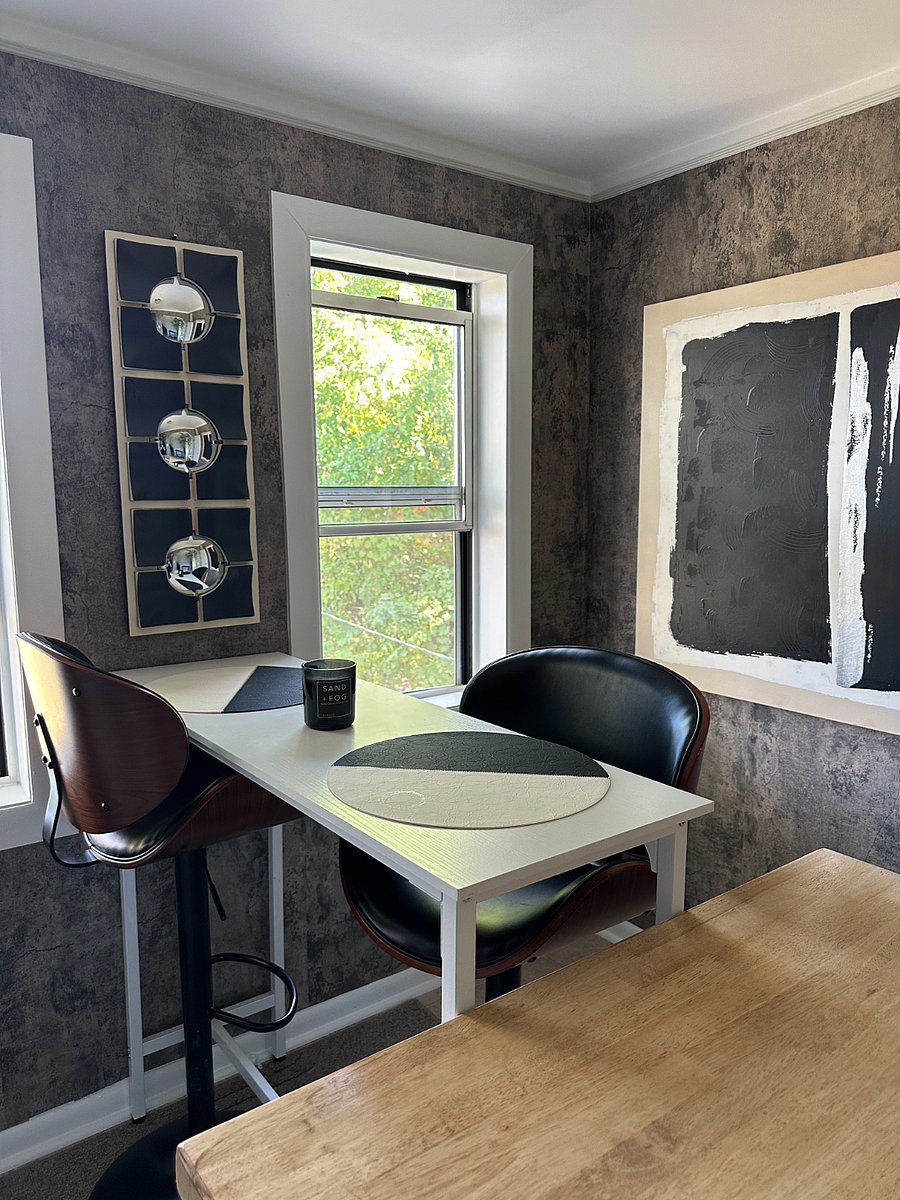 The kitchen offers a high-top dining table with seating for two and lovely views of the backyard.