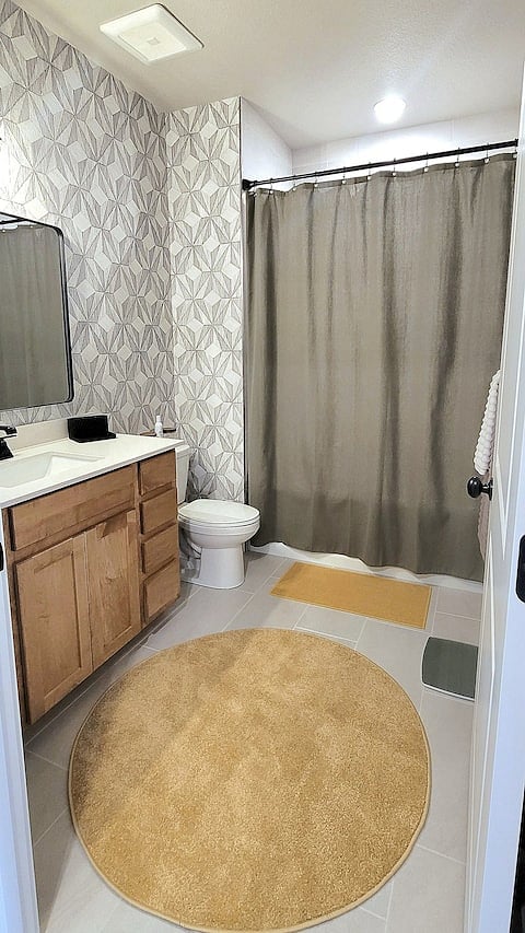 Boring secondary bathroom? Guess again! A stylish, framed mirror replaces the usual ugly glue-on and added funky wallpaper helps to leave you feeling energized and confident going into your days.