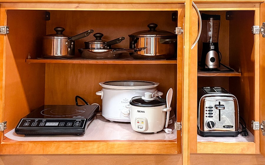 Induction cooktop, stainless steel cookware, slow cooker, rice cooker, blender, and toaster.
