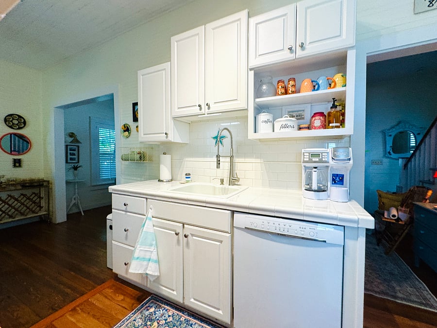Large sink with pro sprayer faucet, garbage disposal, dish cloths and towels, and cleaning supplies.  