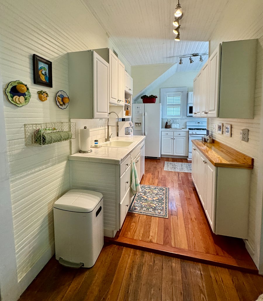 Kitchen with warm wood flooring and bright task lighting.