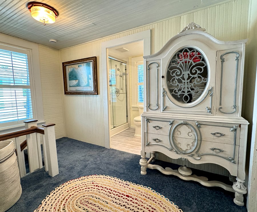 Large upstairs hall with antique armoire with extra linens.