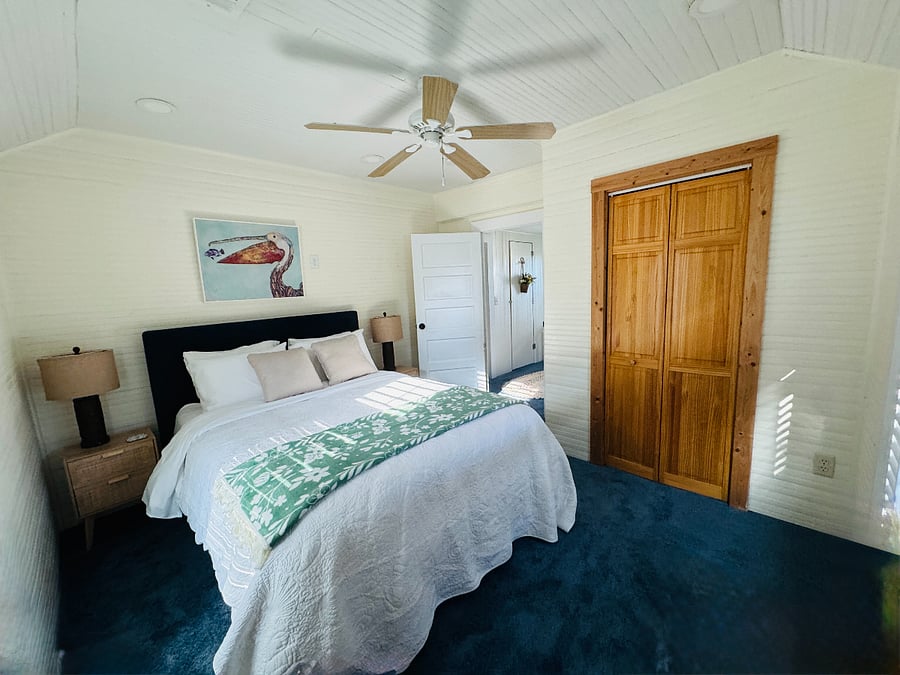 Second queen bedroom with premium bedding, large closet and dresser for storage.