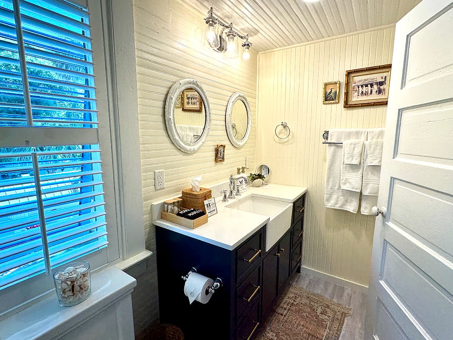 Beautiful primary bathroom with sparkling white quartz countertop and large farm sink.