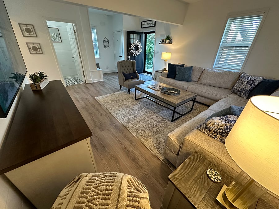 Living Room with comfortable couch, front door and downstairs half bathroom.