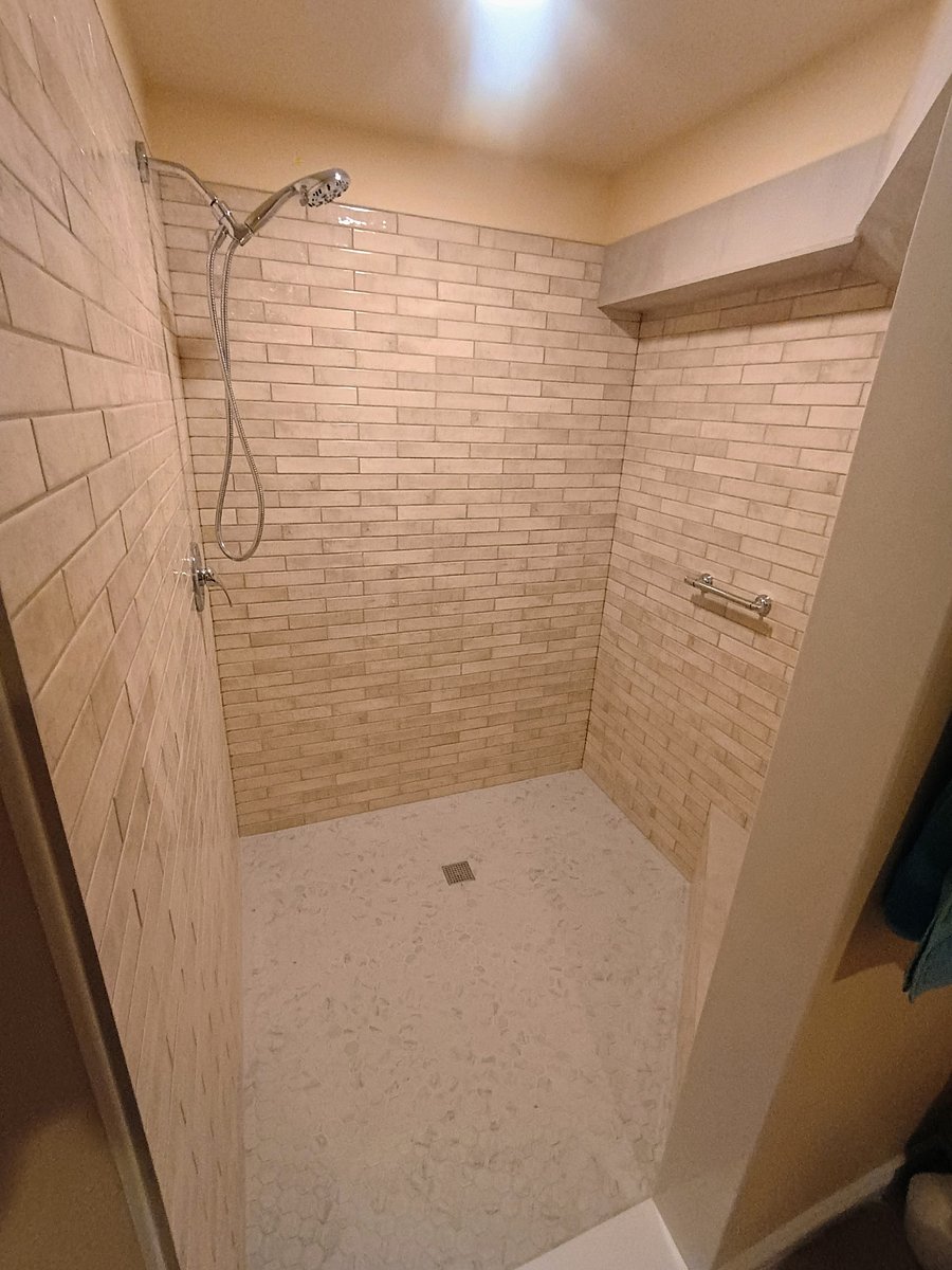 Newly renovated "Gym" shower with seat and cut out space for provided soap and hair products. Handheld showerhead and security bar.