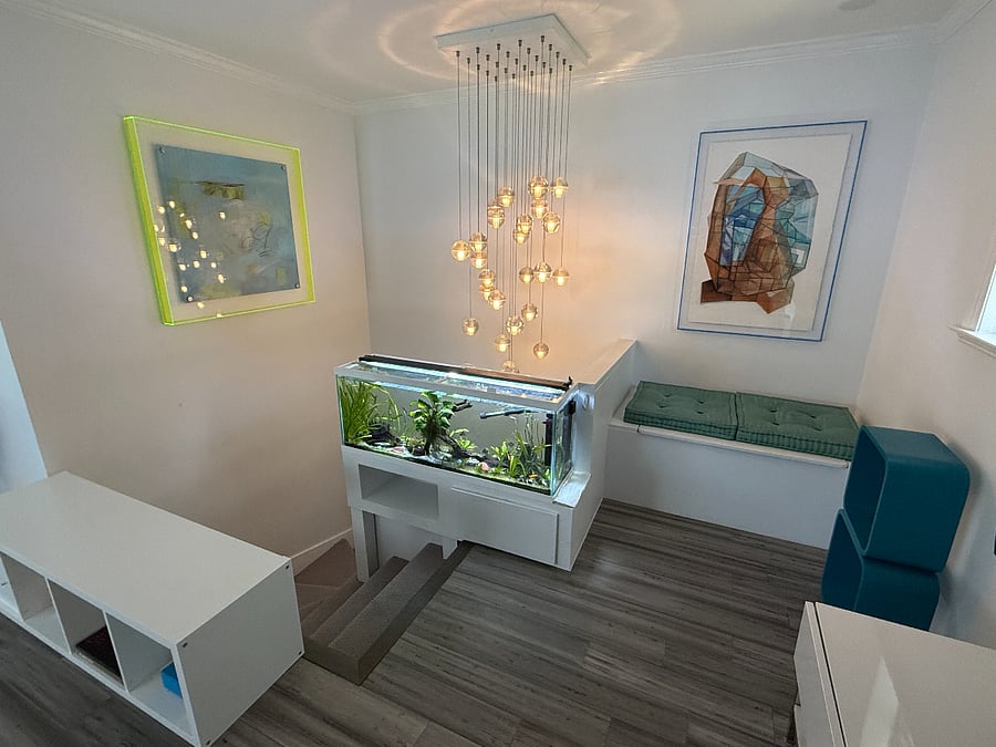 Custom art and a modern chandelier create a clean and minimalist setting. The single-story winding staircase from the front foyer is also a fun entry to the condo. 