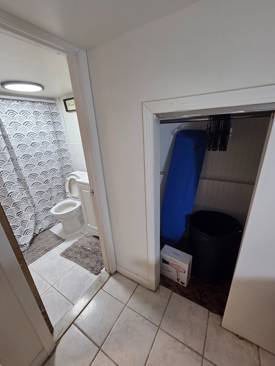 crawl/walk-in closet,nironing board, laundry basket, hair drier, study hanging rod, hangers, bathroom entrance.