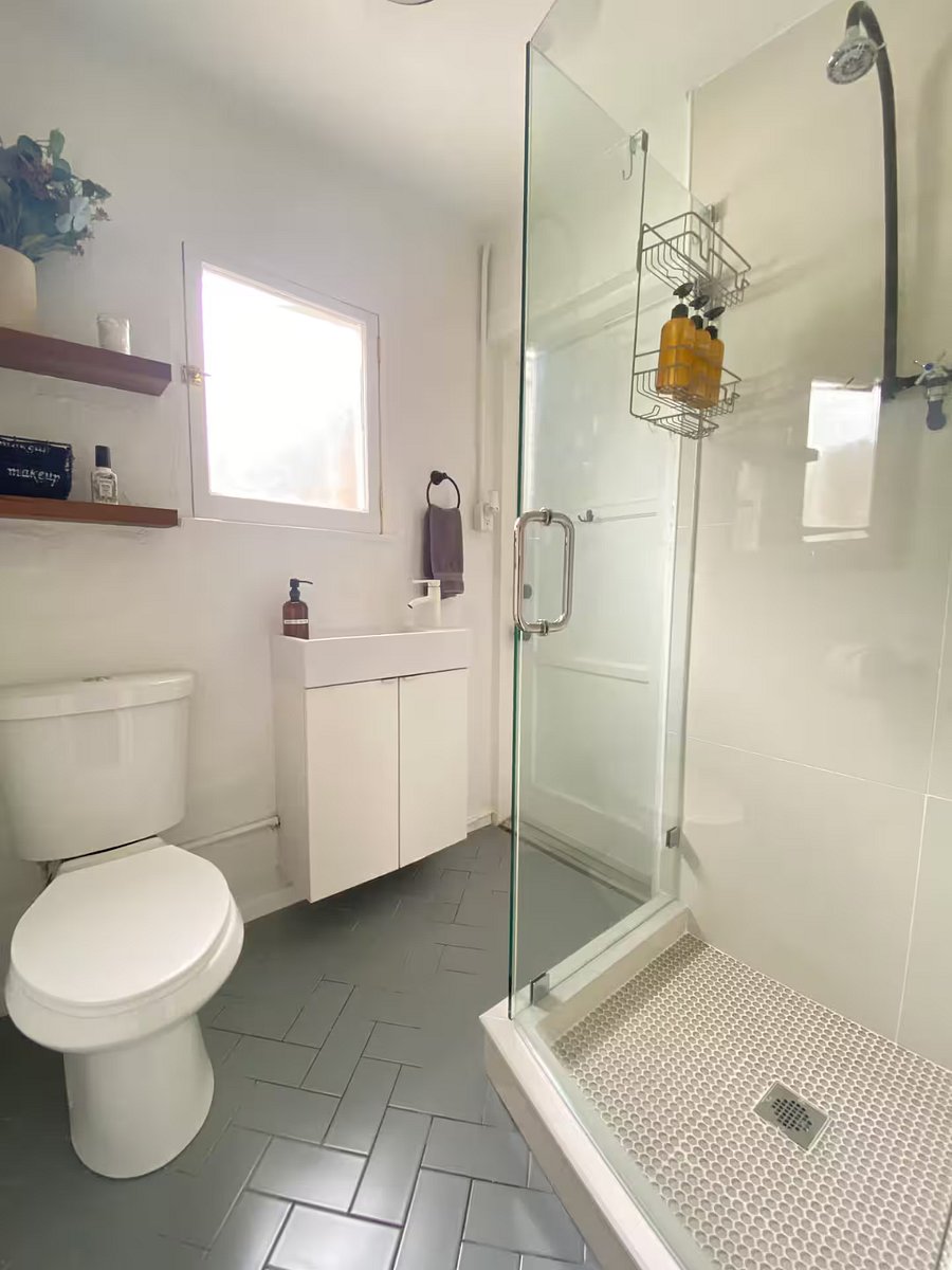 Renovated bathroom with petite shower stall.