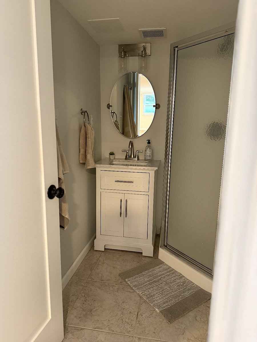 Bathroom features vanity, plush towels and shower.L
