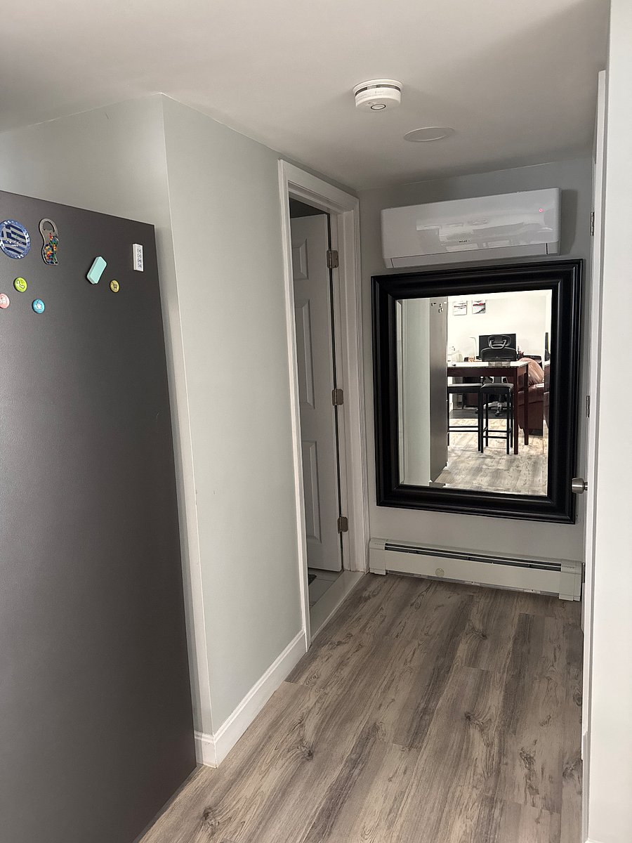 Halway to bathroom with full size mirror.