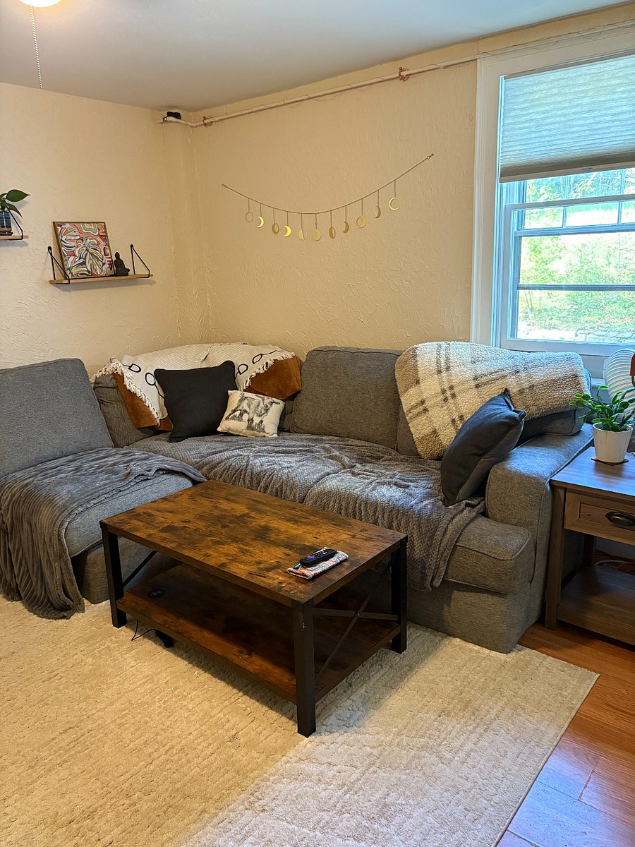 Large comfortable sectional couch with window looking out into backyard.
