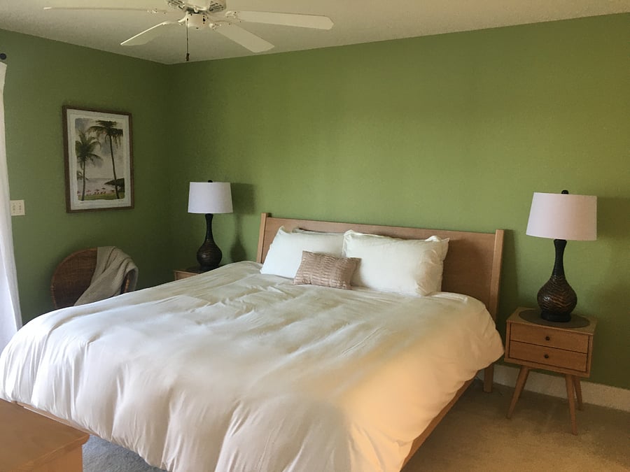 Primary bedroom with a king-size bed, double dresser, and has sliders to the lanai