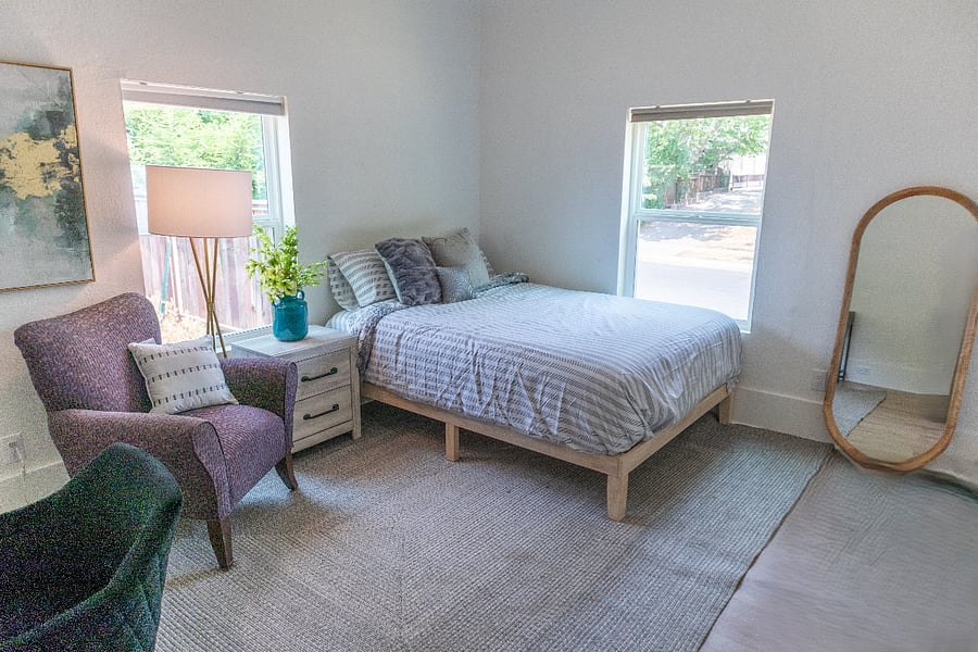 Room with 2 windows, rug and mirror