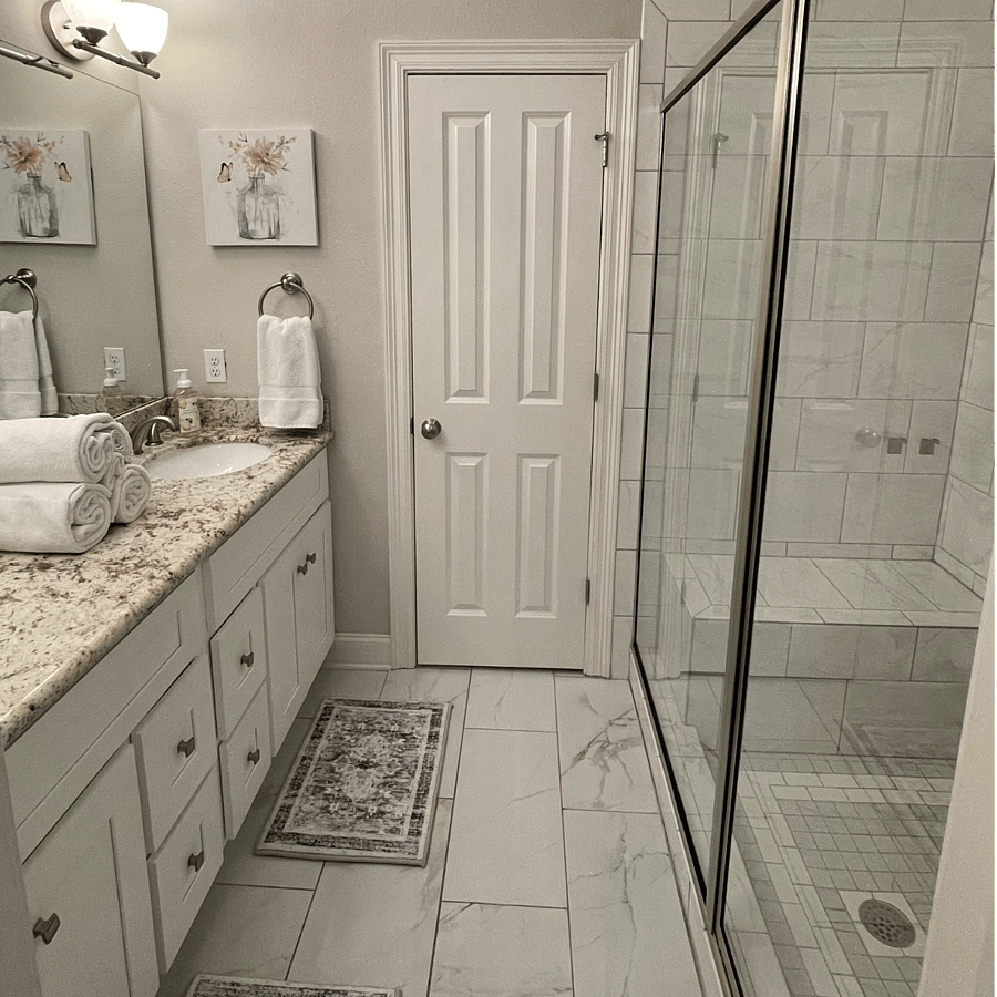 The main bathroom is attached to the front bedroom, featuring double sinks and a walk-in shower