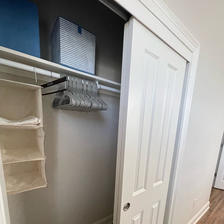 The closet includes hangers and extra storage.