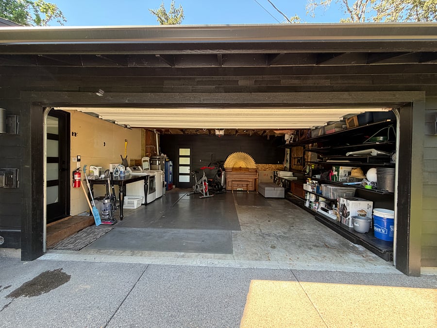 Garage with washer, dryer, laundry table, piano. EV charger to the left of garage door, attached outside.