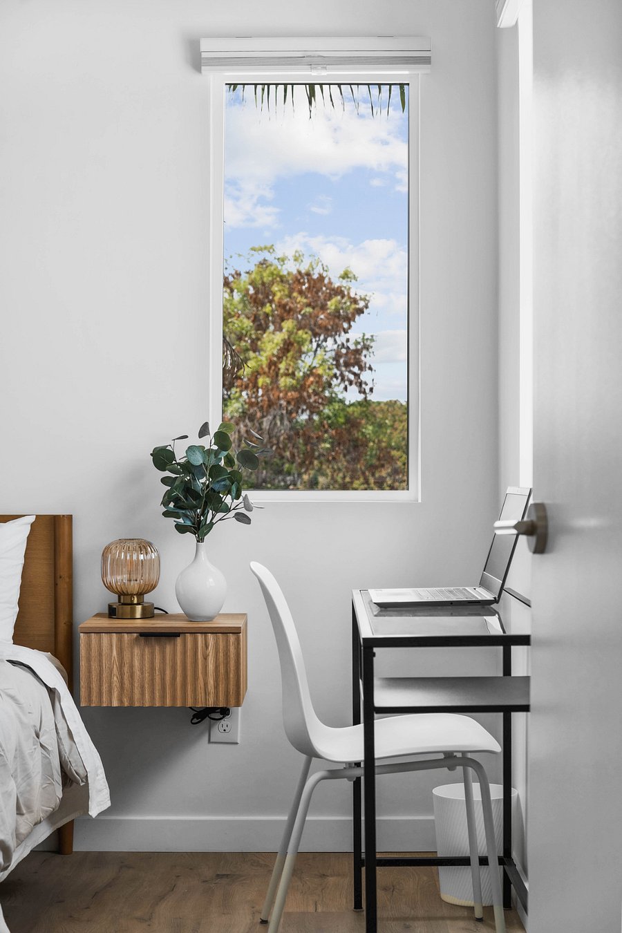 Dedicated work space overlooking trees and rooftops.
