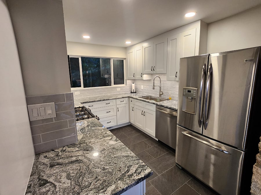 Modern kitchen with new cabinets, countertops and appliances, and a view of beautiful greenery