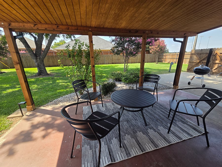 Outdoor back patio with seating and grill