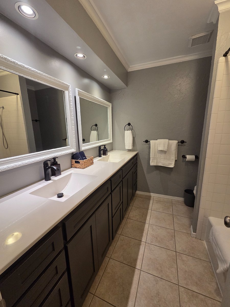 Bathroom with double sinks and bath/shower.