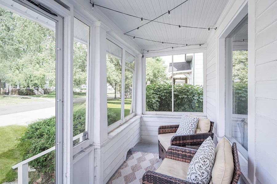 Screened in front porch with chairs and pull out ottomans