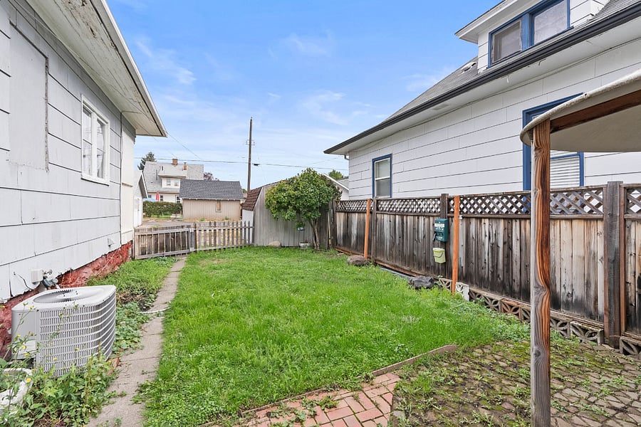 Fully fenced side yard with gazebo seating and dog station