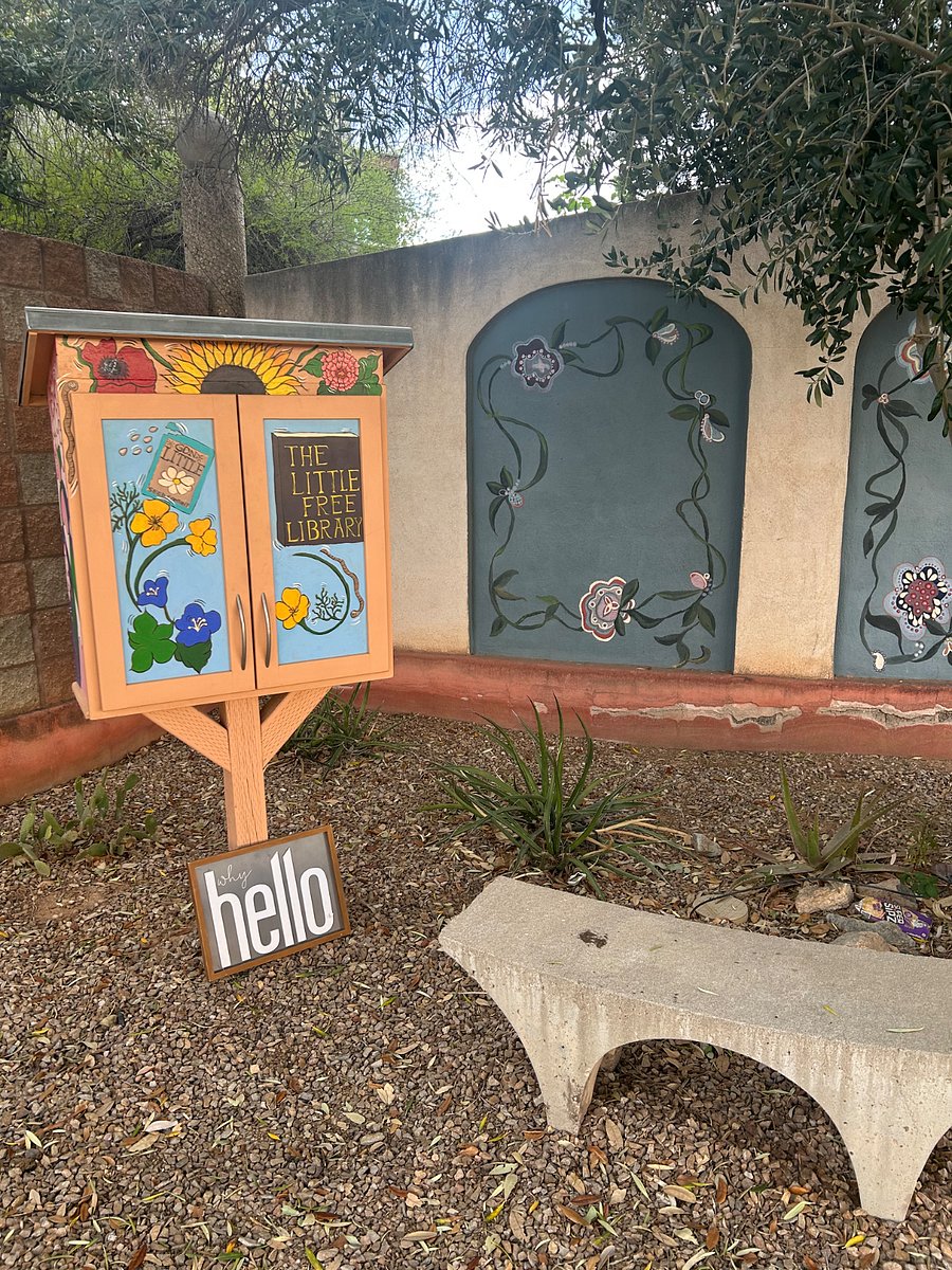 Tiny library and bench next to community garden. 