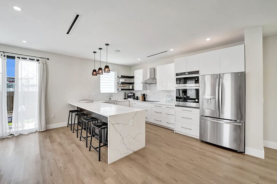 Channel your inner chef in a gourmet kitchen featuring a stunning quartz waterfall island and premium appliances
